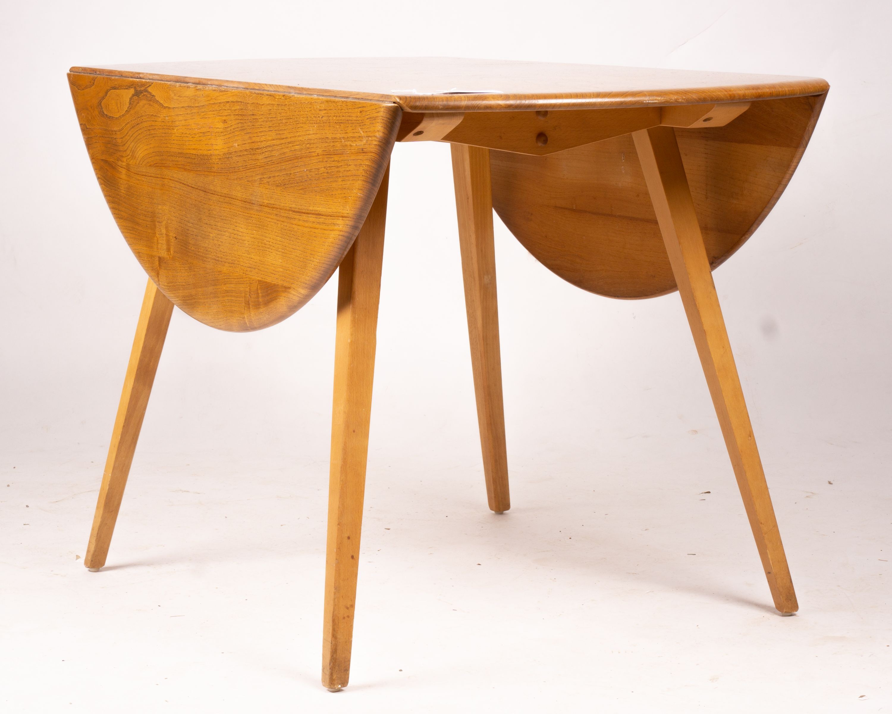 An Ercol light elm and beech circular drop leaf dining table, length 124cm extended, width 113cm, height 72cm